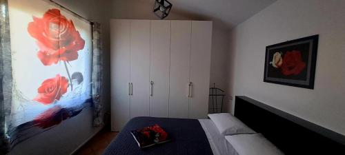 a bedroom with a bed and a large painting on the wall at La rosa rossa in San Gemini