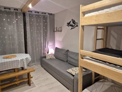a living room with a couch and a bunk bed at Studio LE CORBIER in Villarembert