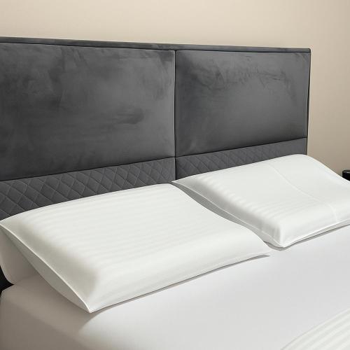 a bed with white sheets and a black headboard at Apartman TONKA Vinkovci - novouređeni apartman u centru Vinkovaca in Vinkovci