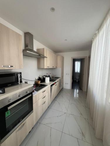 a kitchen with wooden cabinets and a large tile floor at Jasmine court penthouse in Tal-Ħriereb