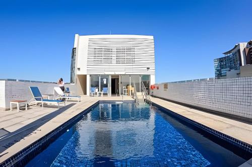 a swimming pool on the roof of a building at Apartamentos Luxuosos a Passos do Mar no Helbor Stay - Airbn Santos in Santos