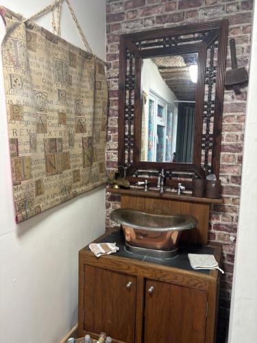 a bathroom with a wooden sink and a mirror at Bridie -rose rural shepherd hut , sleeps 4 with wood fuel hot tub -mini safari -on your doorstep small exotic animals in Kington