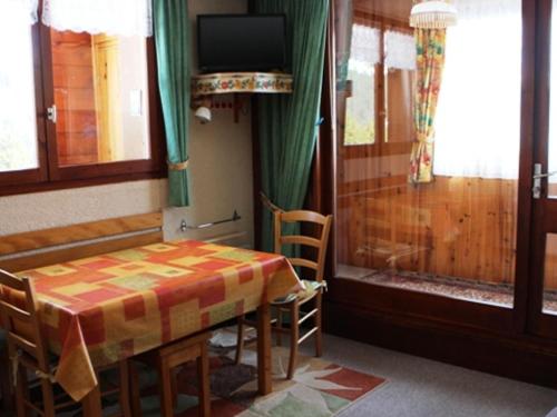 Studio cosy au cœur du village pour 4 pers, proche pistes - FR-1-815-43 في لو براز دي ليس: طاولة وكراسي في غرفة مع تلفزيون