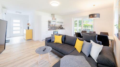 sala de estar con sofá gris y almohadas amarillas en Ferienhaus Klopeiner See, en Unterburg am Klopeiner See