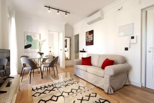 ein Wohnzimmer mit Sofa und Tisch in der Unterkunft AH - Aparta Suites Madrid Río in Madrid