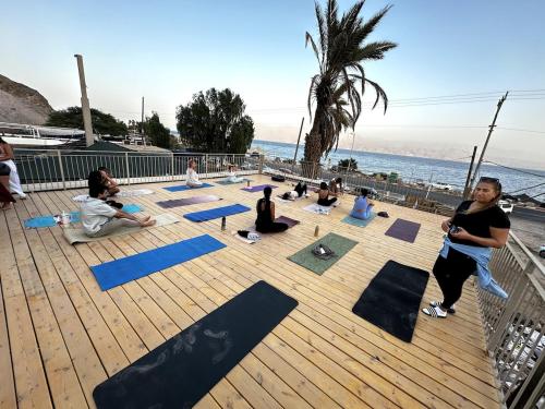 a group of people doing yoga on the beach at כפר הצוללים in Eilat