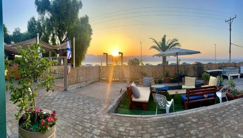 a patio with a table and chairs and an umbrella at כפר הצוללים in Eilat
