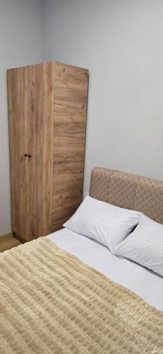 een slaapkamer met een bed en een houten deur bij Apartment TunHomeDom Vagharshapat Armenia in Vagharshapat