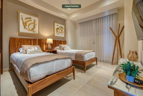 een slaapkamer met 2 bedden en een tafel bij Luxury 2BR Condo in Nuevo Vallarta - Rooftop Pool in Nuevo Vallarta 