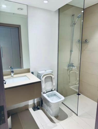 a bathroom with a toilet and a sink and a shower at Chez Teo in Abu Dhabi