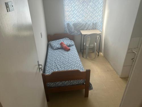a small room with a bed and a table at Suíte 05 no centro da cidade in Uberaba