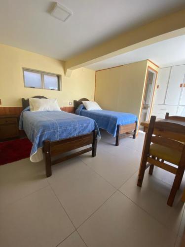 a bedroom with two beds and a bench in it at Residencial Golden in Los Vilos