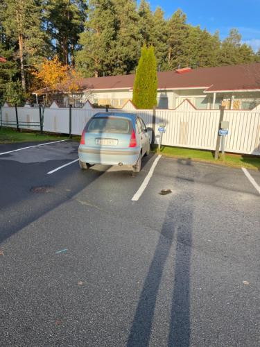 Un coche aparcado en un estacionamiento junto a una valla en Tilava kaksio saunalla, en Seinäjoki