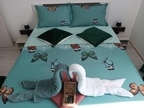 a bed with two swans and a clock on it at Apartament HD3 in Hunedoara