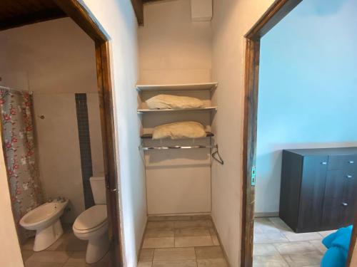 a small bathroom with a toilet and a mirror at Cabañas Cruz del Sur in Miramar