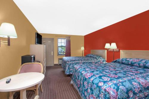 Habitación de hotel con 2 camas y mesa en Knights Inn Wildersville, en Wildersville