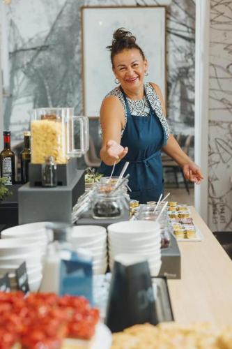 Una donna in piedi dietro un bancone in una cucina di Tartini Residence - Fully Furnished Apartment a Piran