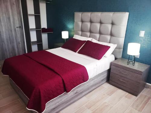 a bedroom with a large bed with a red blanket at 04 Magnífica habitación cerca CAS Consulado, Expo in Guadalajara