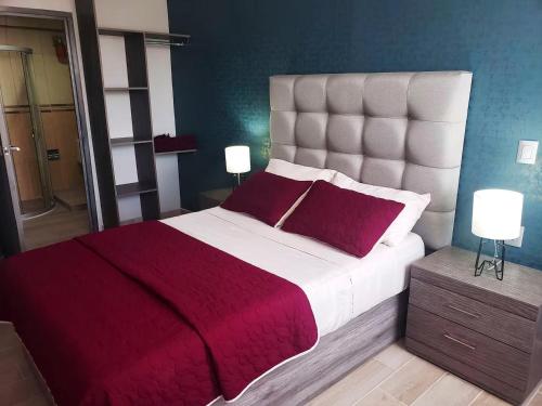 a bedroom with a large bed with a red blanket at 04 Magnífica habitación cerca CAS Consulado, Expo in Guadalajara