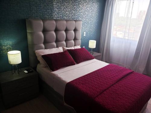 a bedroom with a large bed with a red comforter at 04 Magnífica habitación cerca CAS Consulado, Expo in Guadalajara