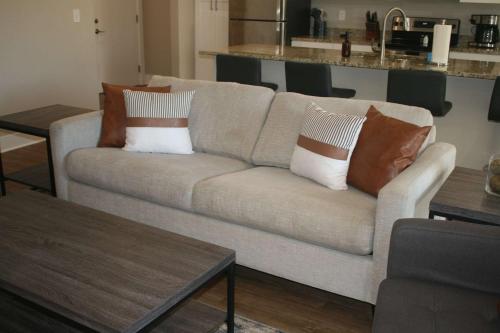 a living room with a couch with pillows on it at Modern 2BR & 2BA Condo with Garage & Patio in Grandville