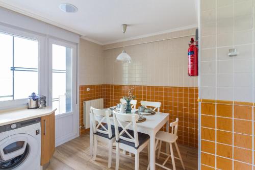 a kitchen with a table and chairs in a room at Etxea iradi in Elejalde