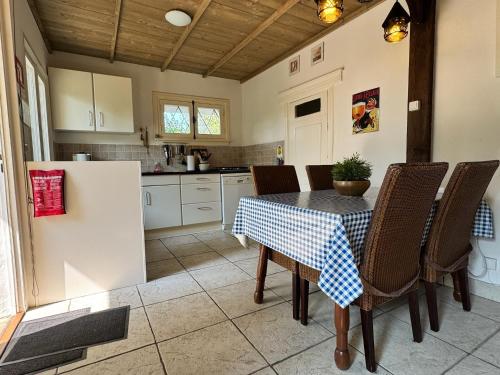 eine Küche mit einem Tisch mit Stühlen und einem Kühlschrank in der Unterkunft Maison Annelore in Saint-Honoré-les-Bains