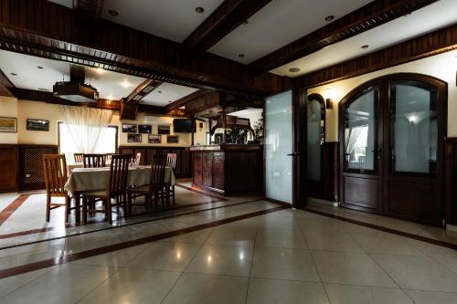 a kitchen and dining room with a table and chairs at Pensiunea Carol Oglinzi in Oglinzi