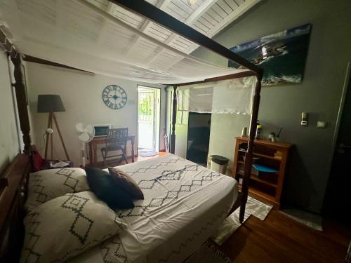 a bedroom with a bed and a clock on the wall at Villa Saphir B & B in Sainte-Anne