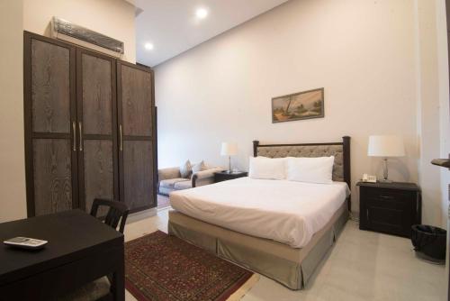 een slaapkamer met een bed en een woonkamer bij Cadillac Hotel in Islamabad