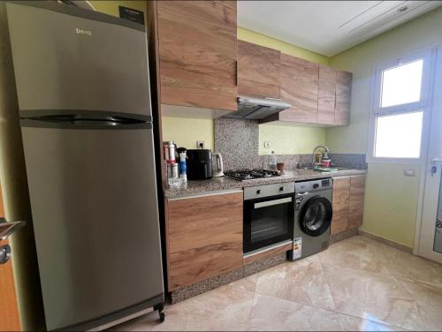 a kitchen with a refrigerator and a stove top oven at Residence kettani in Bouznika