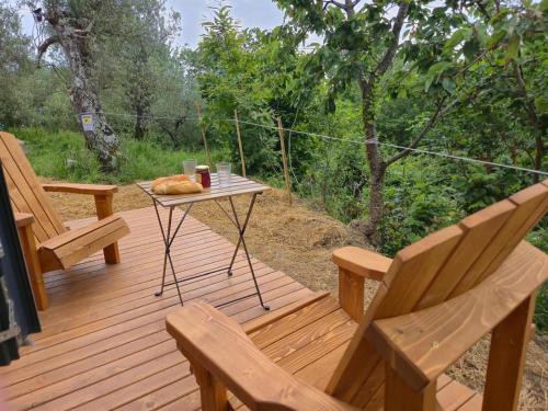 a wooden deck with two chairs and a table with food on it at In the Wild Volcano Sea Side 