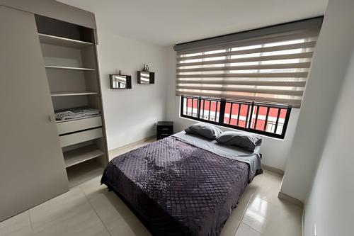 a bedroom with a bed and a large window at Espacioso y Elegante en Milán in Manizales