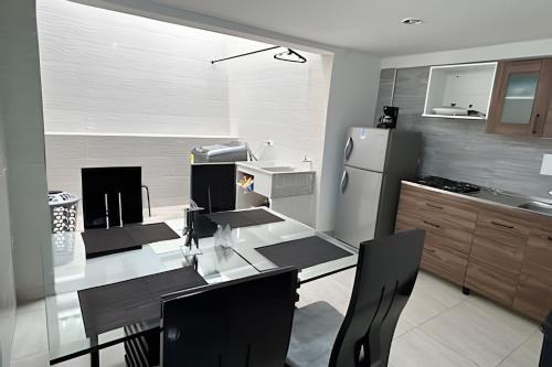 a kitchen with a table and a refrigerator at Espacioso y Elegante en Milán in Manizales
