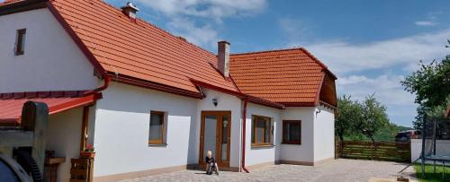 a small white house with an orange roof at Chata Chotár Nová Baňa in Veľká Lehota