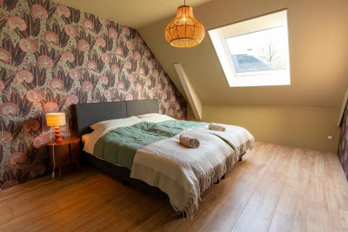 a bedroom with a bed with a flowery wall at Gastenverblijf Hunsingo in Winsum