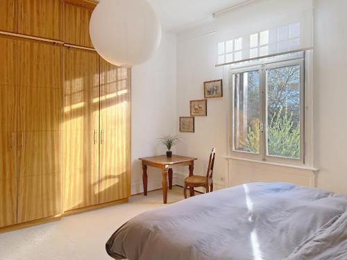 a bedroom with a bed and a table and a window at Strasbourg Tivoli in Strasbourg