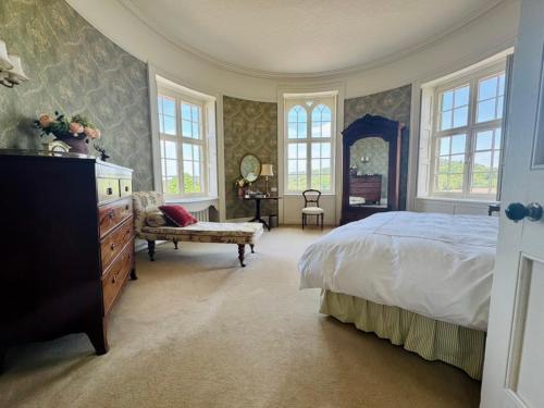 a bedroom with a bed and a dresser and windows at The Citadel in Weston