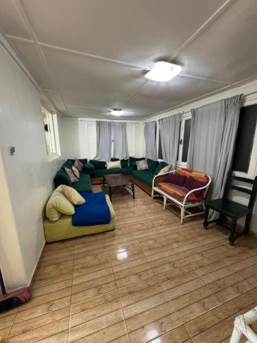 a living room with a green couch and chairs at Cabanon pied sur mer in Mohammedia