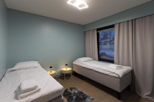 a small bedroom with two beds and a window at Teddy's Hideout in Rovaniemi