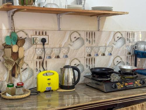 a kitchen counter with a stove and utensils on the wall at Stay Happy at Chathurni Villa, Ahangama in Ahangama