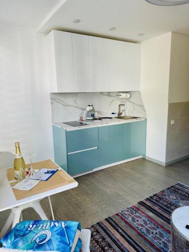 a kitchen with blue and white cabinets and a table at AMBER APARTMENTS - FRESH STUDIO in Morro del Jable