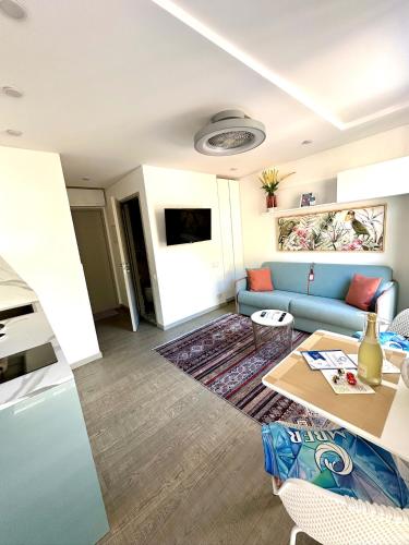 a living room with a blue couch and a table at AMBER APARTMENTS - FRESH STUDIO in Morro del Jable