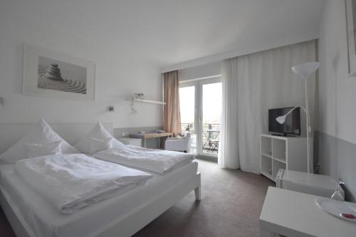 WangenにあるPension Lindeのベッドとテレビがあるホテルの部屋