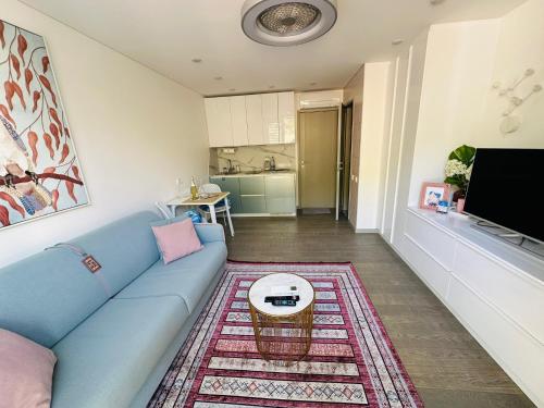 een woonkamer met een blauwe bank en een tafel bij AMBER APARTMENTS - PINK STUDIO in Morro del Jable