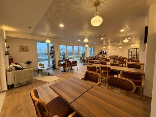 Un restaurante con mesas y sillas en una sala. en Reflets de Seine, en Aubergenville
