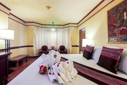 a hotel room with a bed with two towels at Duangtawan Hotel Chiang Mai in Chiang Mai