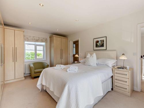 a bedroom with a large white bed and a chair at 2 Bed in Cartmel LCC47 in Cartmel