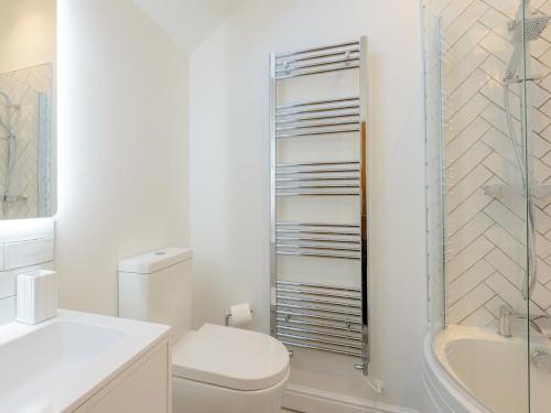 a white bathroom with a toilet and a tub at 2 Bed in Cemaes Bay 77640 in Llanfechell