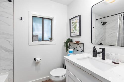 een witte badkamer met een wastafel en een spiegel bij Luxury A-Frame with Hot Tub, Fireplace & Firepit in Skykomish